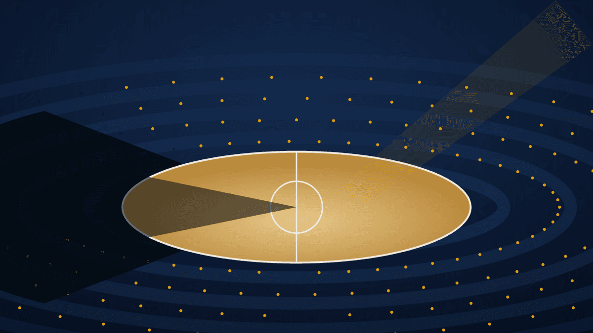 A brightly lit NBA arena with one section of seating cast in shadow, illustrating local blackout restrictions.
